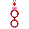 Colgante de acetato en rojo y rosa tranparente, con una bisagra que hace que se transforme en gafas de lectura. Collar hecho en cordón de algodón fucsia, abalorio de cristal en forma de corazón y fornituras plateadas.