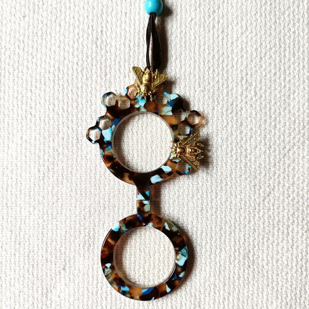 Medallón-gafas de acetato en tonos carey y turquesas, realizado en acetato y con abejas metálicas en color dorad. Rematado con collar de terciopelo con abalorio en color turquesa.Transformable en gafas de lectura.