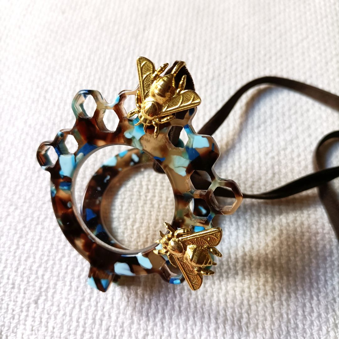Medallón-gafas de acetato en tonos carey y turquesas, realizado en acetato y con abejas metálicas en color dorad. Rematado con collar de terciopelo con abalorio en color turquesa.Transformable en gafas de lectura.