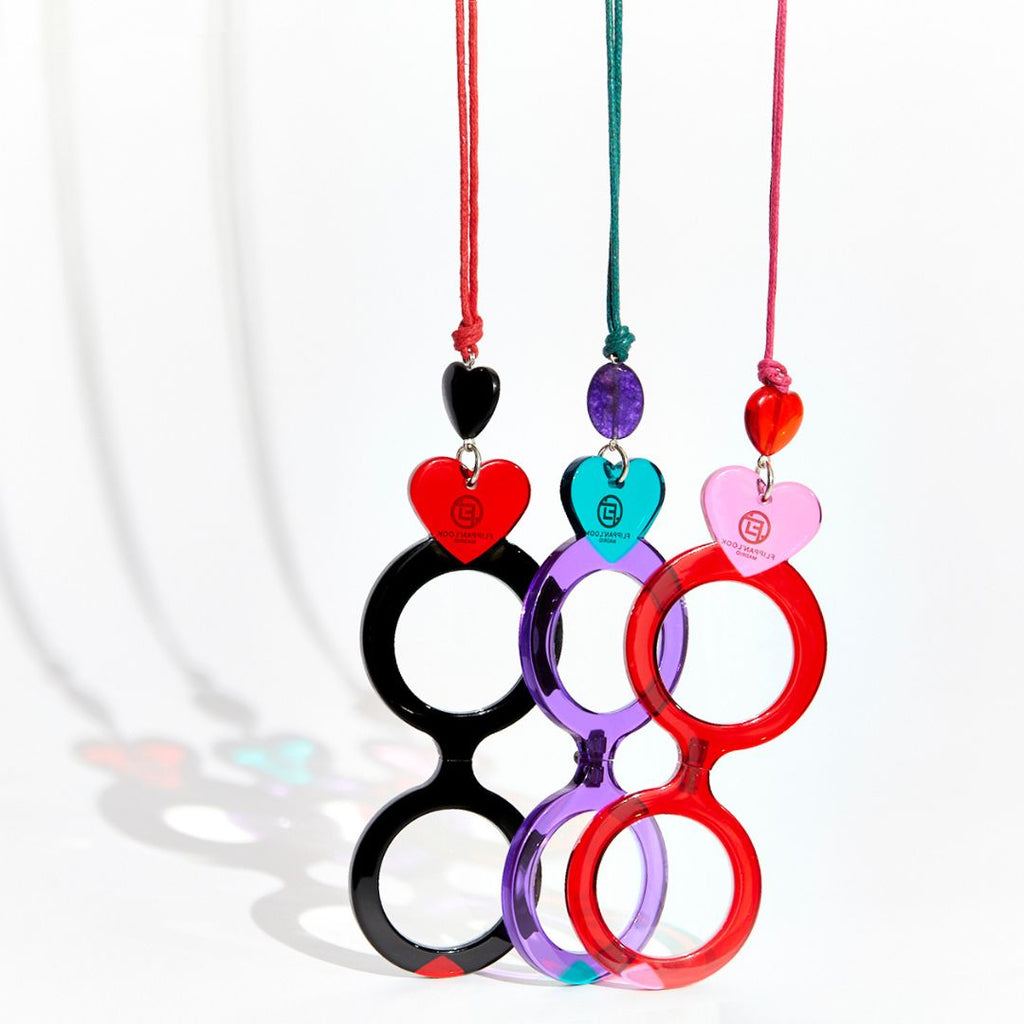 Colgantes gafas en forma de corazón en combinaciones de colores negro y rojo, morado y verde y rojo y rosa